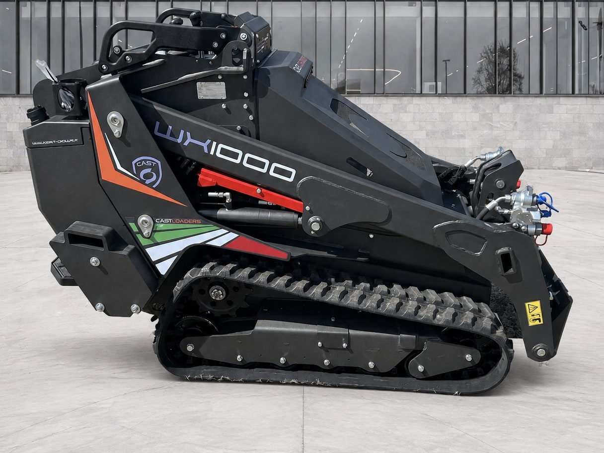 The same CAST WX1000 mini skid steer on a concrete forecourt in front of a glass building.