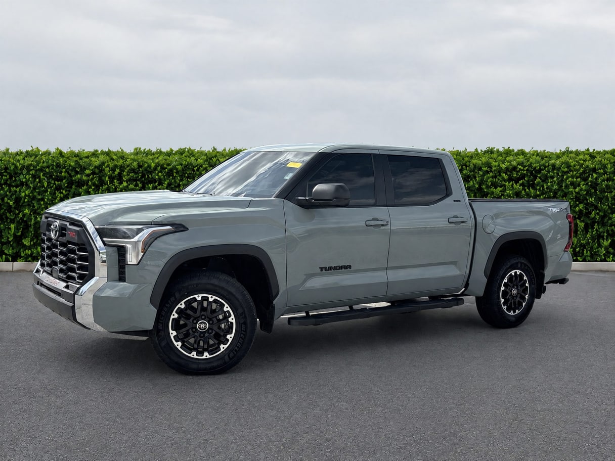 The same Tundra on plain asphalt in front of a trimmed hedge.